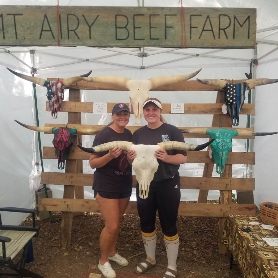 Couple holding Longhorn steer skull and horns inside Mt. Airy Beef tent at Backwoods Fest in Thornville, Perry County, Ohio.