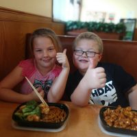 Children giving thumbs up for their meals at Cheng's Gourmet Chinese restaurant in New Lexington, Perry County, Ohio.