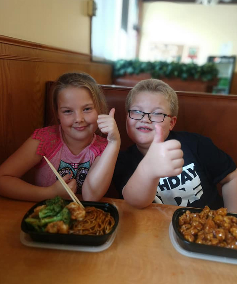 Children giving thumbs up for their meals at Cheng's Gourmet Chinese restaurant in New Lexington, Perry County, Ohio.