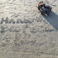 RC dune buggy on sand with Hannah Brothers written in the sand.