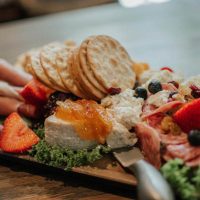 Charcuterie board from Horvath's Harbor with crackers, meats, cheeses and fruits.