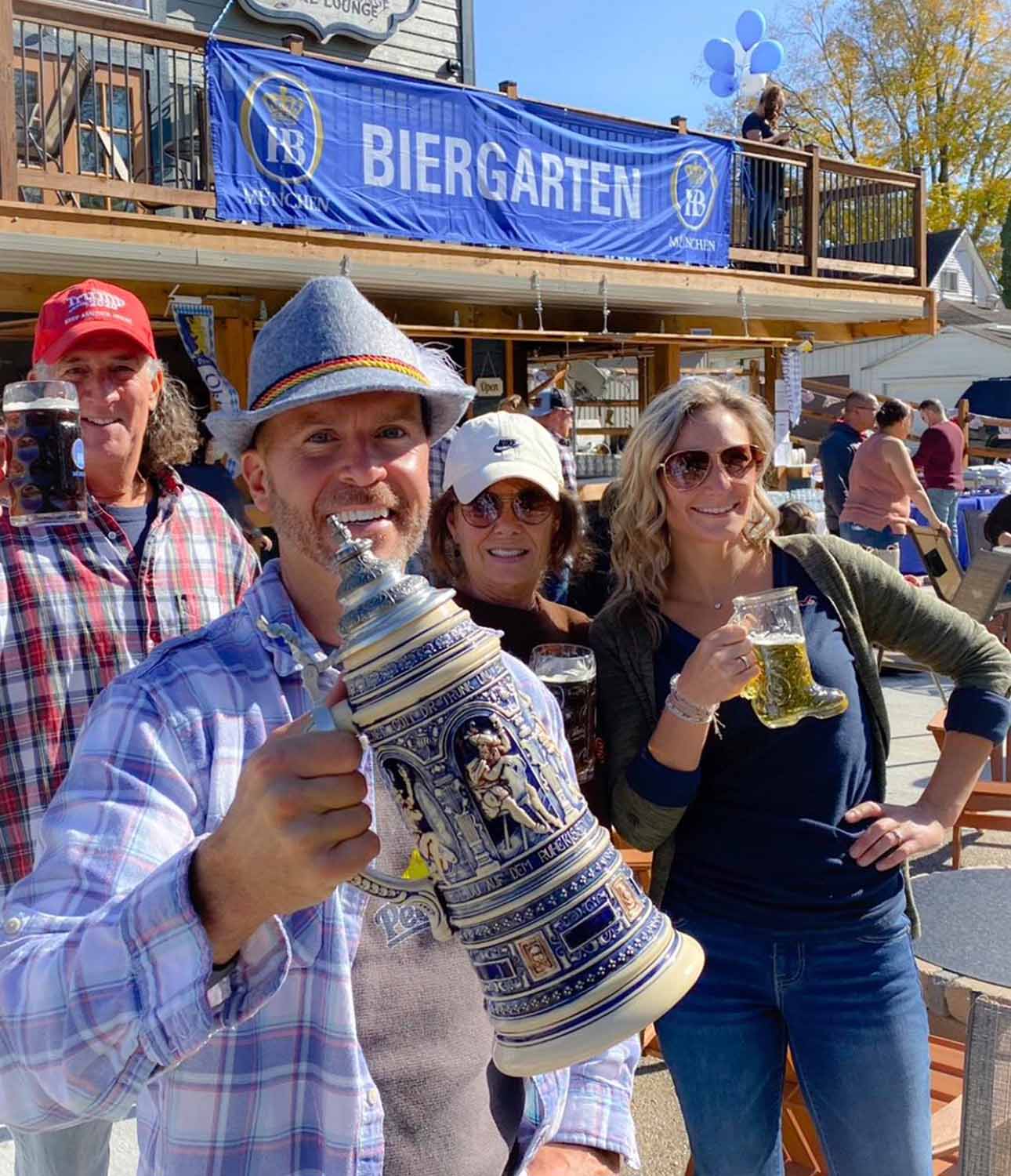 People holding up tankards of beer on a patio under an Oktoberfest banner at Horvath's Harbor, Thornville, Perry County, Ohio.