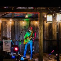 Guitarist playing at night on patio stage at Horvath's Harbor in Thornville, Perry County, Ohio.