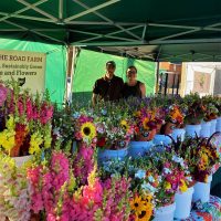 Lauren and Zack, owners of Down the Road Farm in New Lexington, Perry County, Ohio, standing at their flower stand.