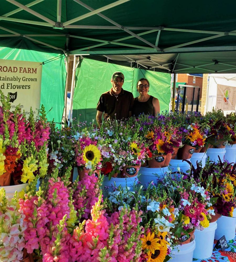 Lauren and Zack, owners of Down the Road Farm in New Lexington, Perry County, Ohio, standing at their flower stand.