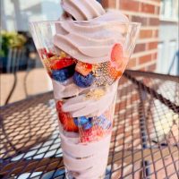 Tall strawberry frozen yogurt with fresh fruit on table in front of Perrydise Frozen Yogurt in Somerset, Perry County, Ohio