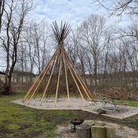 Tipi with log seating and fire pits at Cherokee Valley Bison Ranch