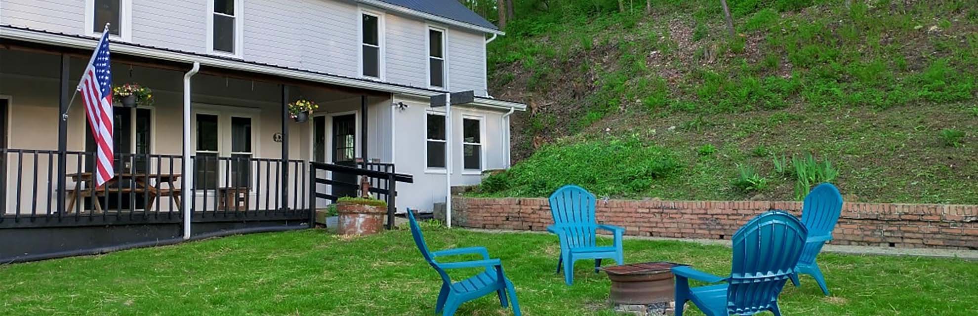 Bigfoot Lodge exterior with chairs and firepit on lawn in New Straitsville, Perry County, Ohio.