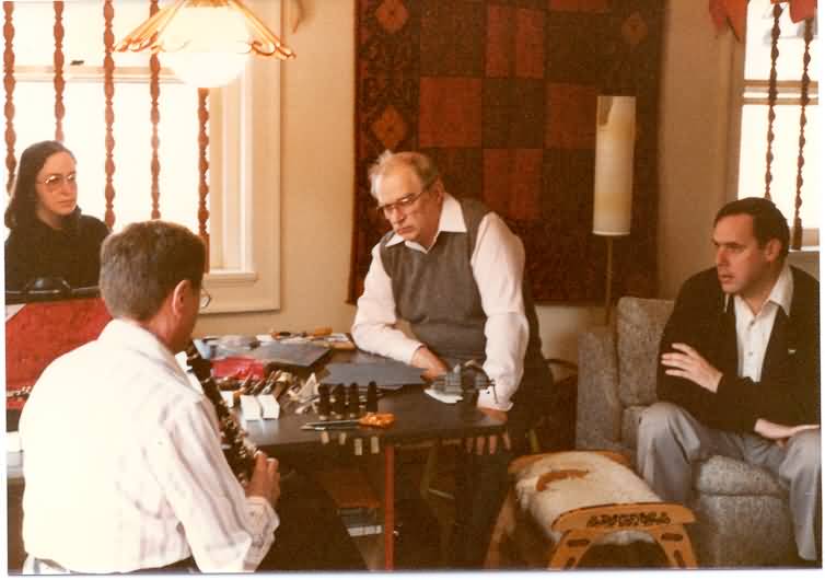 1970s-era photograph of famed inventor of the clarinet mouthpiece, David Hite, conferring with others in a living room.