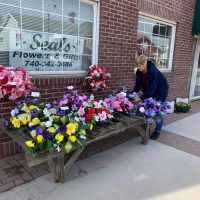 Woman arranging floral display outside the entrance at Seals Flowers & Gifts in New Lexington, Perry County, Ohio