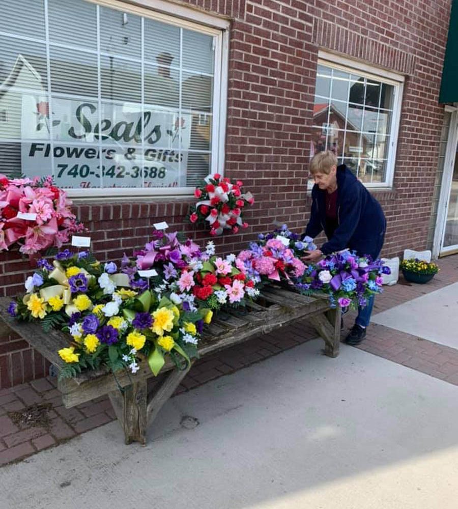 Woman arranging floral display outside the entrance at Seals Flowers & Gifts in New Lexington, Perry County, Ohio