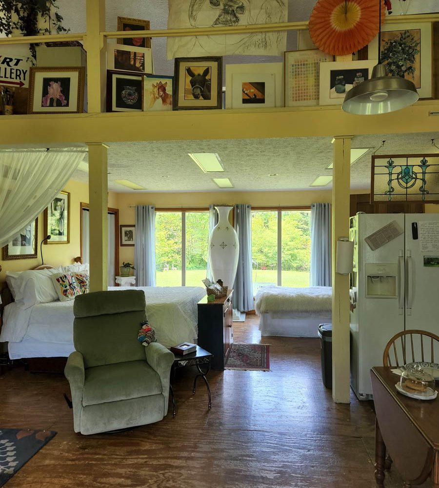 Artist's space accommodations with bed, kitchen and artwork on display at Acres of Nature in Perry County, Ohio.